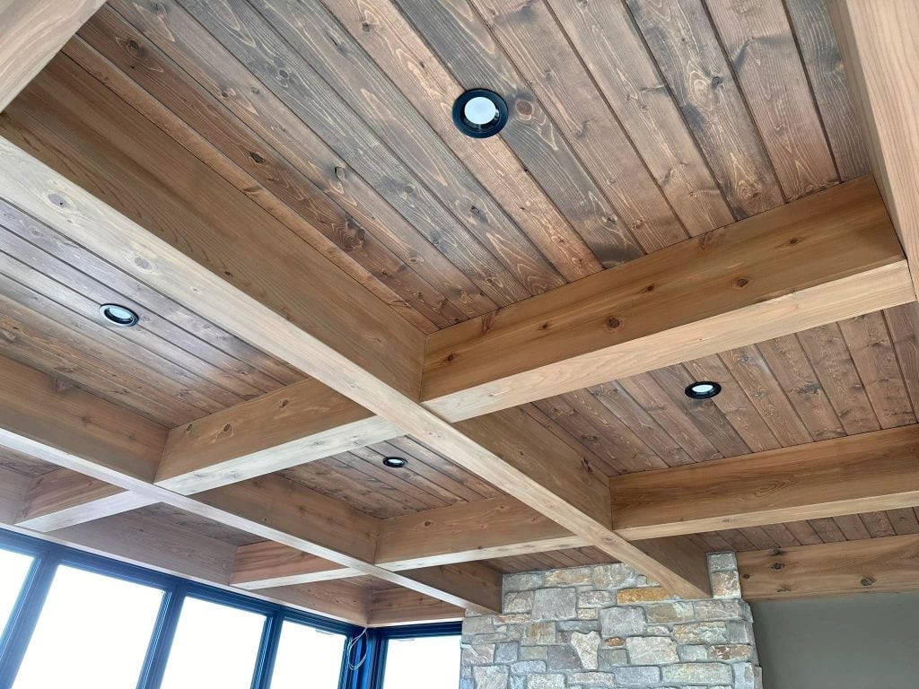 A close-up of a beautifully finished wooden ceiling with recessed LED lights, showcasing craftsmanship in interior painting and decorating.
