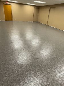 An image showcasing a freshly painted, durable epoxy floor in a commercial or office space, emphasizing professional painting and decorating services.