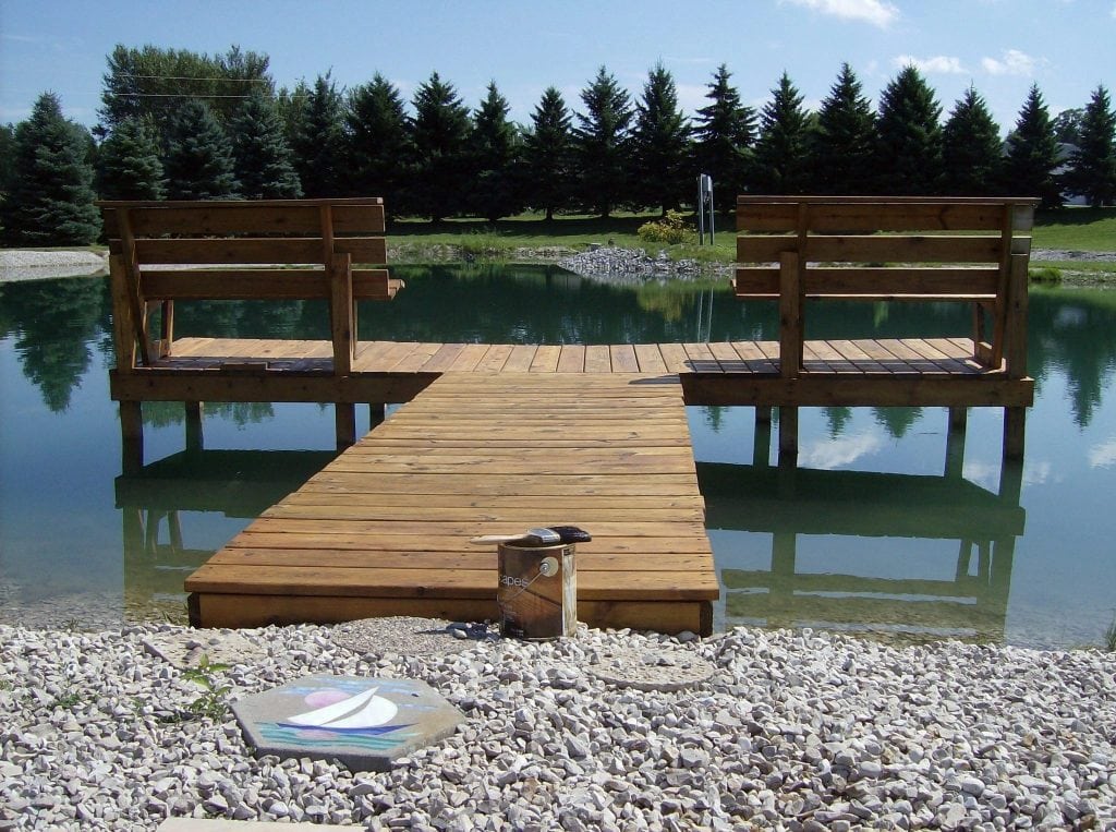 Relaxing lakeside scene with a wooden dock and benches, ideal for outdoor painting and decorating projects.